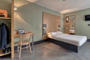塔尔诺斯B&B HOTEL Bayonne Tarnos的一间卧室配有一张床和一张桌子及椅子