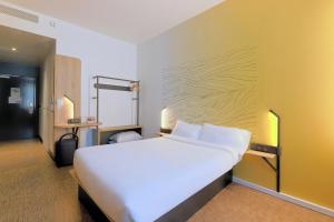 屈克B&B HOTEL Le Touquet的卧室配有一张白色大床和黄色墙壁