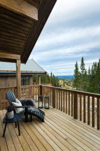 奥耶Cozy modern holiday villa with electric car charging, sauna and fireplace的木制甲板上设有长凳和椅子