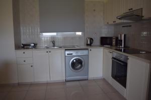 帕福斯Eden Heights Sea View Apartment 203 - By IMH Travel & Tours的厨房配有白色橱柜和洗衣机。