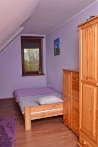 厄尔科B10 Dom LUX z Alpakami & Basen SPA的一间卧室配有一张床、一个梳妆台和一扇窗户。