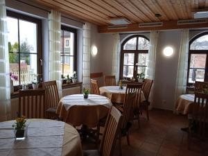 施尔奇Pension Drei Elstern的用餐室设有桌椅和窗户。