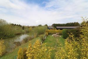 布里德灵顿Little Eden Country Park, Bridlington with Private Hot Tubs的河边花园,有楼