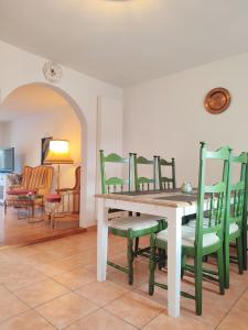 博登斯边的拉多夫采尔Haus Mediterran - Gemütliches Ferienhaus 130 m² für max. 7 Personen mit Balkon und Garten am Bodensee的一间带桌子和绿色椅子的用餐室