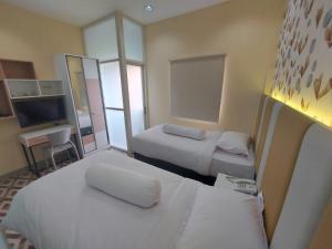 WonocoloRumah Familiku 1 Syariah的酒店客房设有两张床和电视。