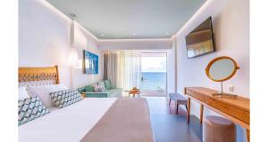 依拉佩特拉佩特拉马雷酒店的一间卧室配有一张床、一张书桌和一面镜子