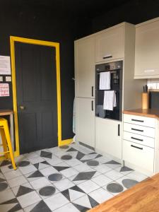 纽马基特Suffolk pink house, Newmarket town centre的厨房铺有黑白的格子地板。