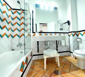 格拉纳达Hotel Rosa De oro的浴室配有盥洗池、卫生间和镜子。