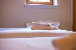 卡伦德Crown Hotel的一张白色的床,上面有一条毛巾