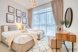 迪拜Serene 2BR at Acacia A Dubai Hills Estate By Deluxe Holiday Homes的一间卧室设有两张床、镜子和窗户