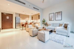 迪拜Serene 2BR at Acacia A Dubai Hills Estate By Deluxe Holiday Homes的客厅配有沙发、椅子和桌子