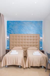 米兰Hotel Repubblica的卧室内的两张床,墙上有绘画作品