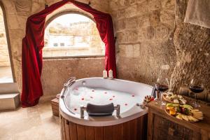 于尔居普Kayata Cave Suites Special Class的窗户客房内的浴缸