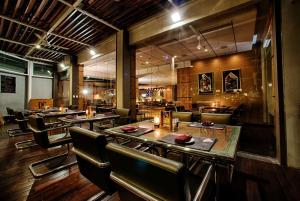 雅加达Wyndham Casablanca Jakarta的一间带桌椅的餐厅和一间酒吧