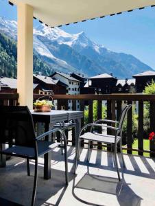 夏蒙尼-勃朗峰Mont Blanc 25, vue Mont blanc, balcon, parking的山景阳台上配有两把椅子和一张桌子
