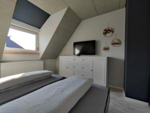 青斯特BooHouse的阁楼卧室配有两张床和电视。