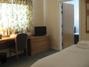 布里真德黑泽尔伍德酒店的一间卧室配有一张桌子、一台电脑和一张床