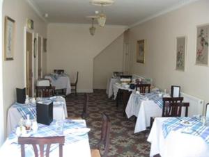 布里真德黑泽尔伍德酒店的用餐室配有桌椅和白色桌子