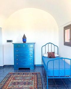 潘泰莱里亚dammuso dehors的一间卧室配有蓝色梳妆台和蓝色的床