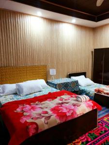 罕萨Hikal Guest House的一间卧室配有两张鲜花床。