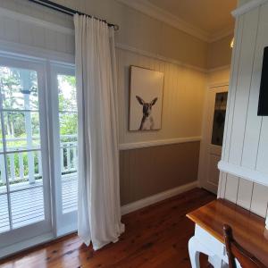 Mount GloriousMaiala Park Lodge的一间房间,墙上挂着一幅狗的照片,窗户上有一个窗口