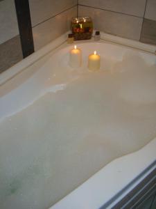 布尔加斯Guest House Lazur的浴缸里放着两根蜡烛和两根蜡烛
