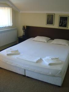 布尔加斯Guest House Lazur的一张白色的大床,带两条毛巾