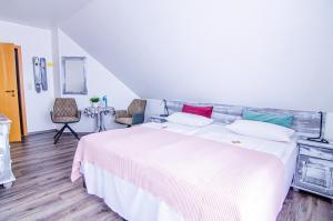 卡罗利嫩西尔Hotel Blischke的卧室配有一张白色大床和两把椅子