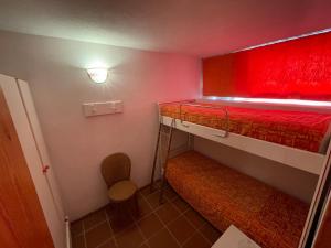 坎尼吉翁Appartamento vista mare a Tanca Manna - Cannigione的小房间设有两张双层床和椅子