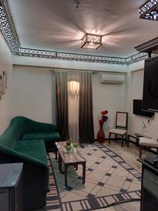 达哈布Shabana House的客厅配有绿色沙发和电视