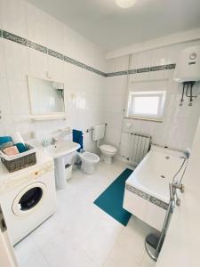 波雷奇Villa Nina Poreč的浴室配有卫生间水槽和洗衣机。