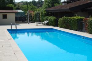 马内尔巴Villino Vacanze "Il Porticciolo"的庭院里带椅子的蓝色游泳池
