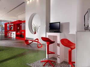 帕特雷爱若特佩特雷智能酒店的客厅配有红色椅子和电视