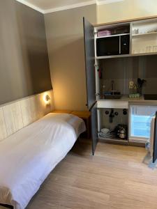 鲁汶博德郝行酒店的小房间设有床铺和微波炉