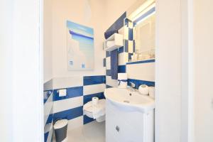 伊斯基亚Apartment Casa Suite Teresa , centro di Forio , Ischia的蓝色和白色的浴室设有水槽和卫生间