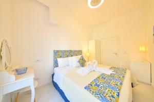 伊斯基亚Apartment Casa Suite Teresa , centro di Forio , Ischia的一间白色的卧室,配有一张带弓的床铺