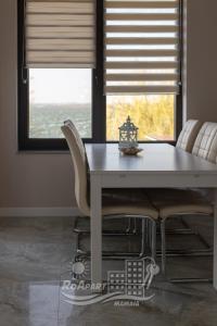 马马亚RoApart Mamaia- Sunset Dream的餐桌、白色椅子和窗户