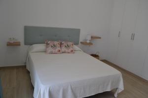 加的斯APARTAMENTO LUPA的卧室配有白色的床和两个枕头