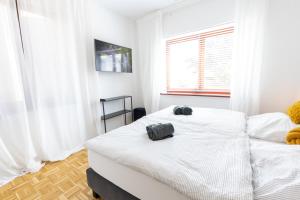 兰施泰因Lahn Living II - Modernes Apartment mit Balkon的一间卧室设有两张白色的床和窗户