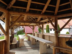 ManiowyOśrodek Wypoczynkowy EDEN Maniowy的木凉亭,带长椅和桌子