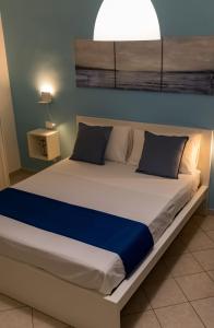 玛格丽塔萨沃亚Blu Salina - Casa Vacanze的卧室内的一张大床,上面有灯