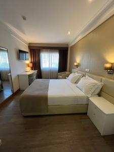 波尔图斯库洛酒店的一间带白色大床的卧室和一间房间