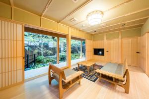 高野山高野山 宿坊 恵光院 -Koyasan Syukubo Ekoin Temple-的一间带桌子、长凳和电视的房间