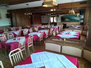 ZweiersdorfGasthof Mohr的用餐室配有粉色和白色的桌椅