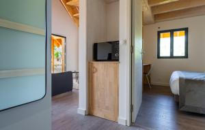 托农莱班Les Cottages de Ripaille的一间房间,配有一张床和橱柜上的电视