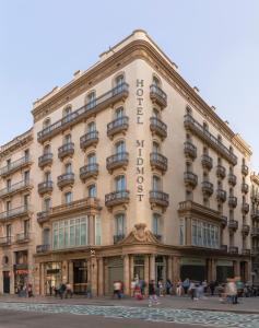 巴塞罗那Hotel Midmost by Majestic Hotel Group的一座大型建筑,前面的人在步行