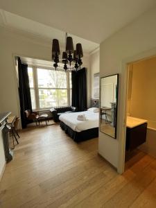 奥斯坦德巴黎人酒店的一间卧室设有一张床和一个大窗户