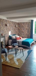 ChervalMaison blanche的一间卧室配有一张床、一张桌子和一张地毯。