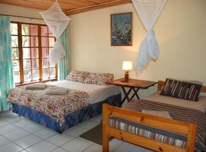 ManguziKosi Moon Bed and Breakfast的一间卧室设有两张床、一张桌子和一个窗口