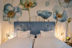 巴特维塞Boutique Hotel Relais Chalet Wilhelmy的卧室配有一张挂着蓝色鲜花的床。